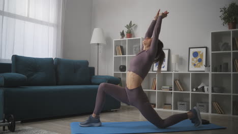 Yoga-Übungen-Zu-Hause-Eine-Schlanke-Frau-Trainiert-Im-Wohnzimmer-Beim-Morgentraining-Am-Wochenende-Und-Führt-Kriegerpose-Dehnübungen-In-Asanas-Durch